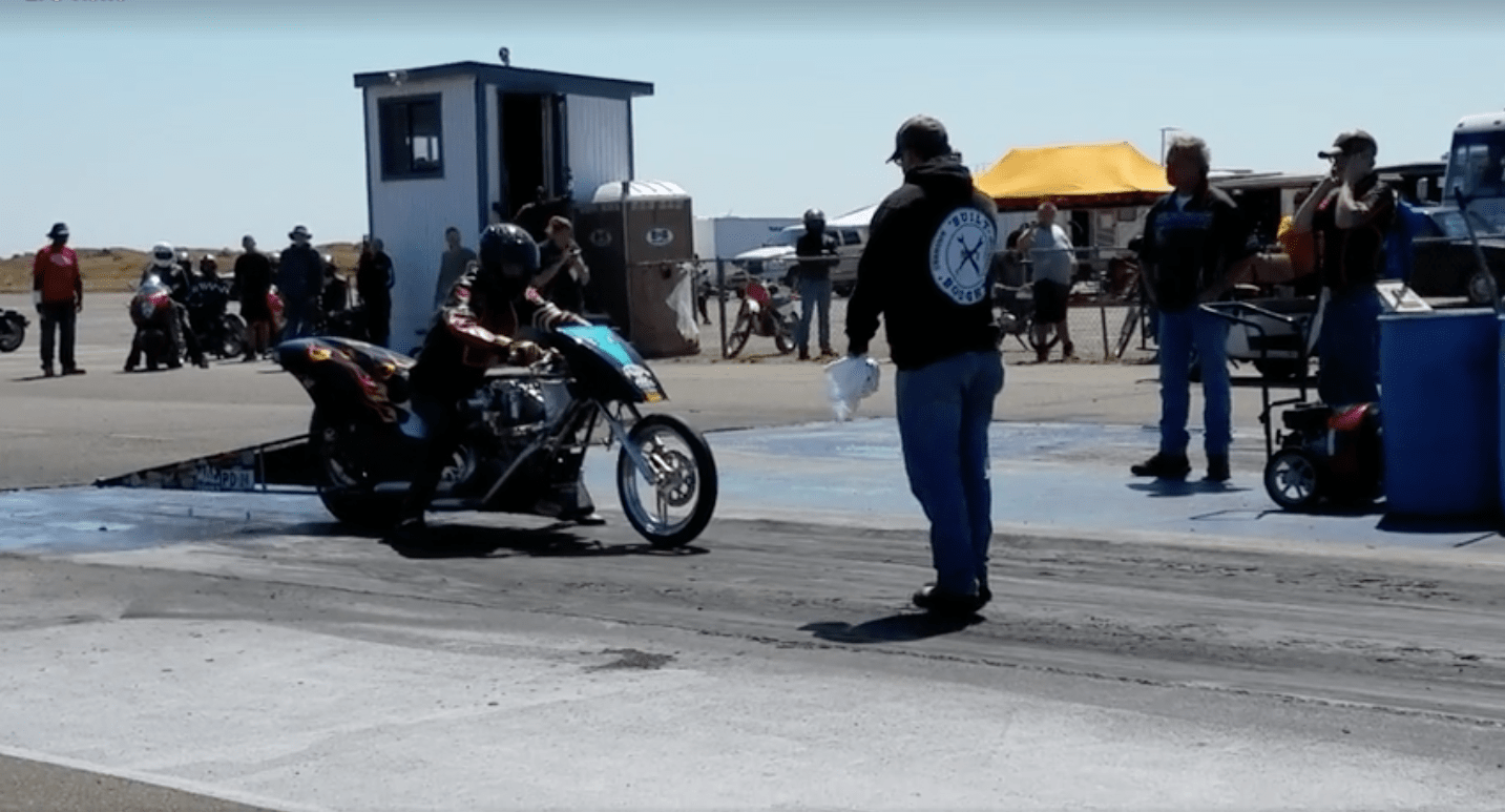 Motorcycle takes a small fall just before starting drag race